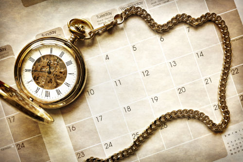 Gold Pocket Watch on a Calendar