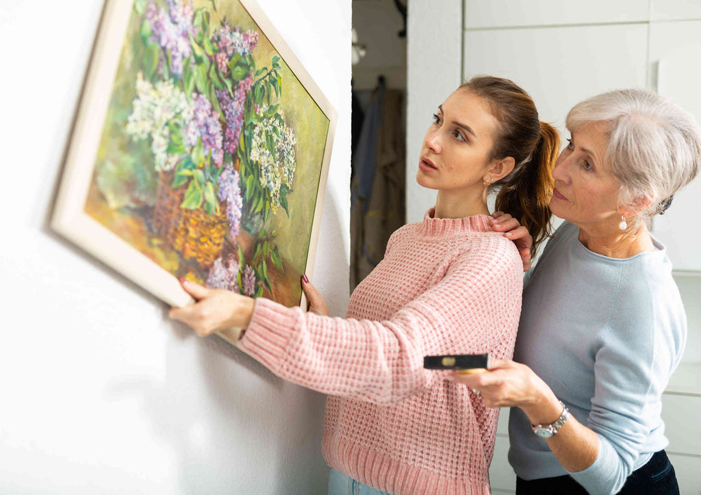 Two Women Hanging a Classic Painting